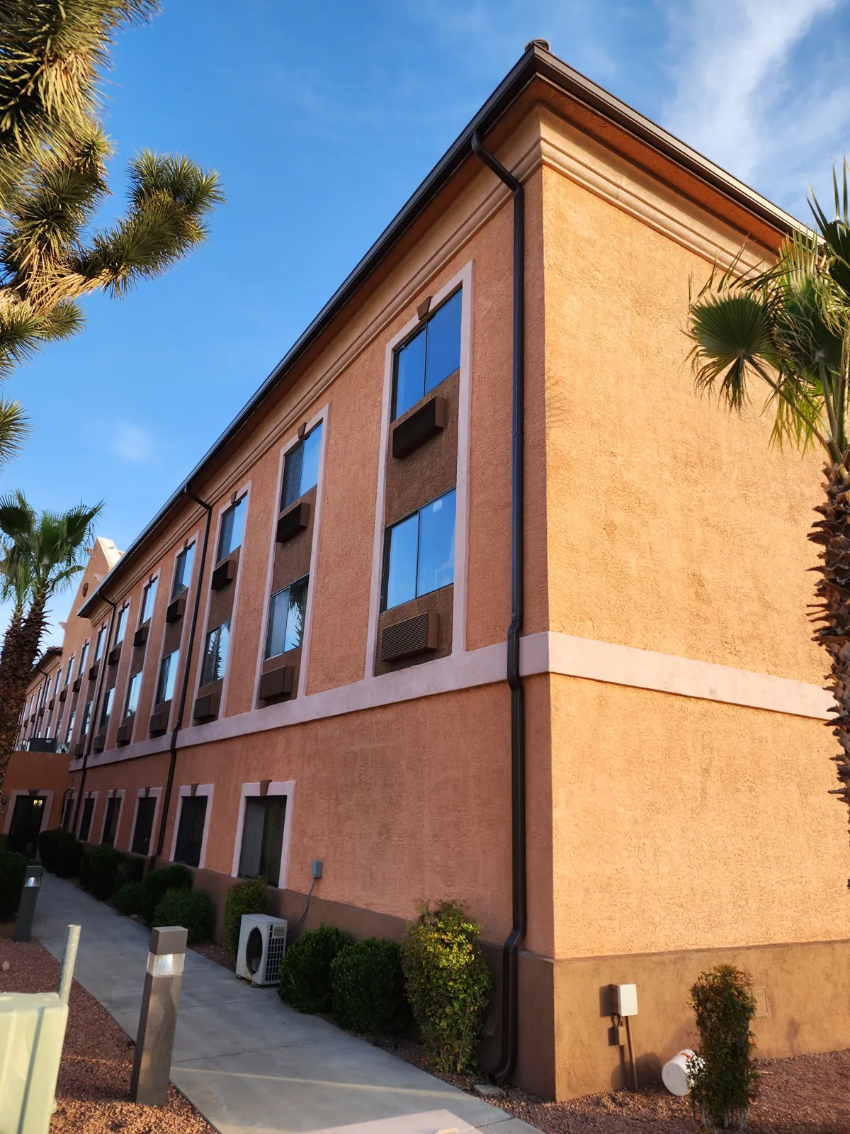 Seamless gutters and corner downspouts on a two-story stucco commercial building in Las Vegas, NV