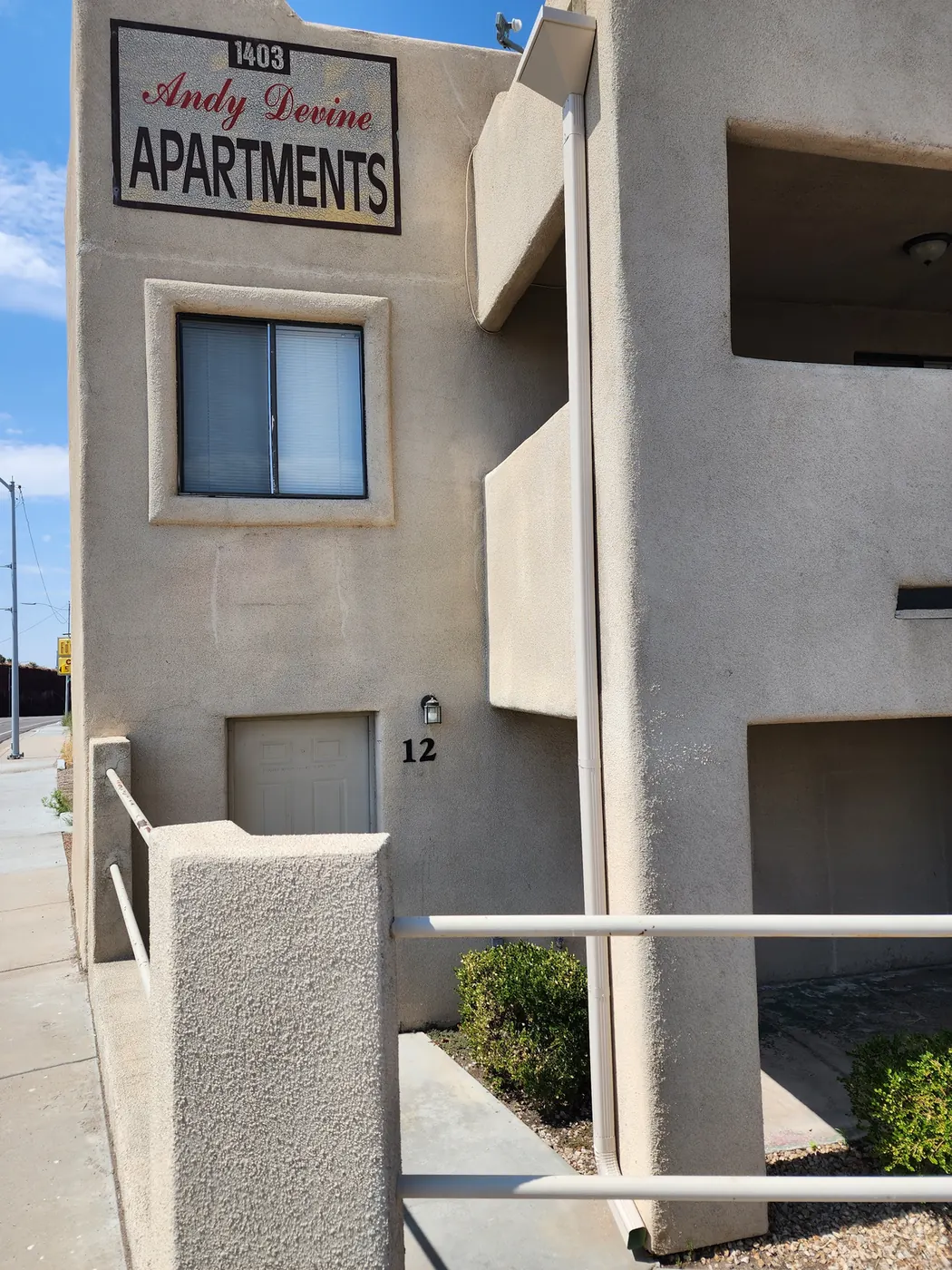 White seamless aluminum gutter and downspout on the Andy Devine Apartments multifamily building in Kingman, AZ
