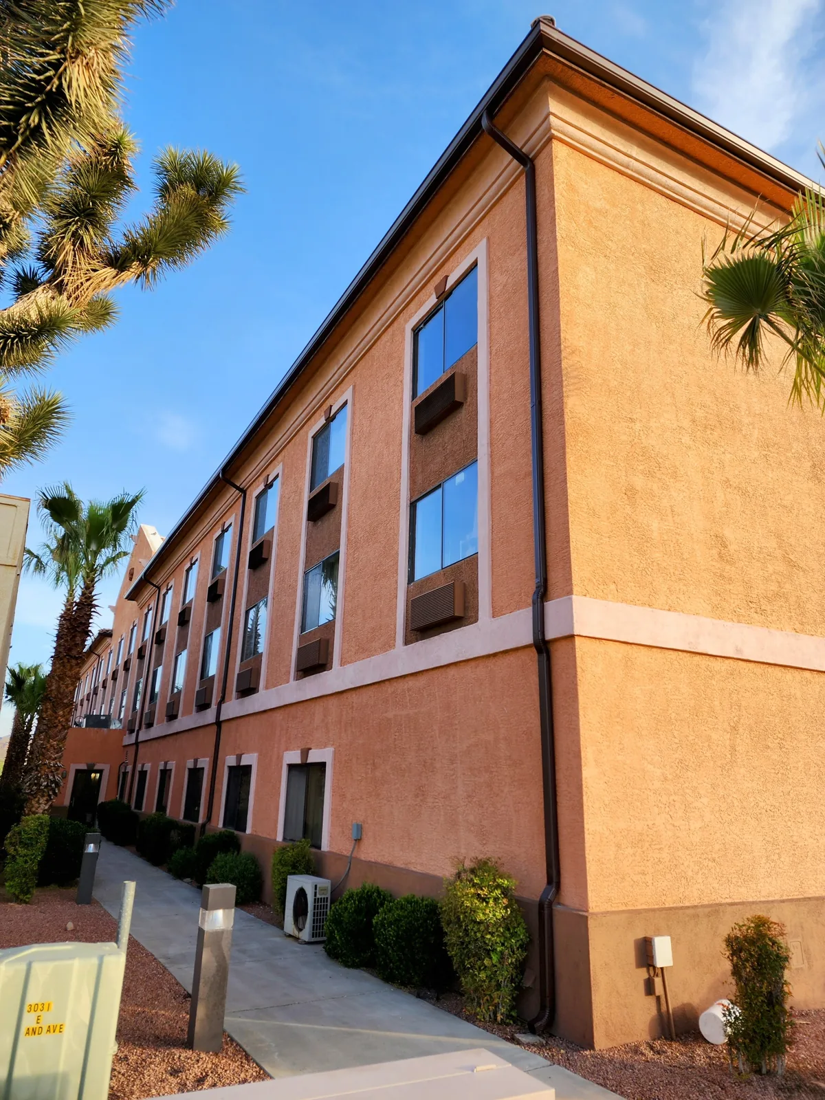 Dark brown seamless aluminum gutters and downspout on a two-story commercial stucco building in Las Vegas, NV
