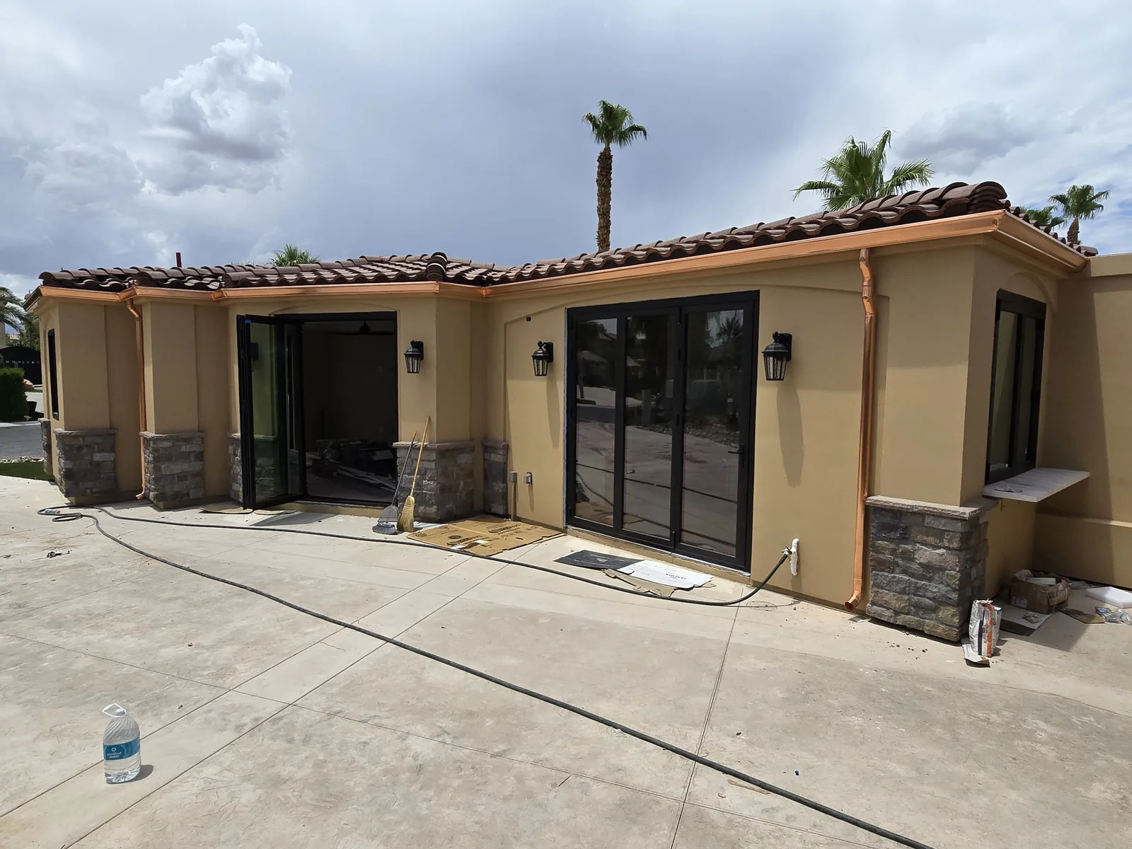 Genuine copper seamless gutters and downspouts on a tan Tuscan tile-roof home in Las Vegas, NV