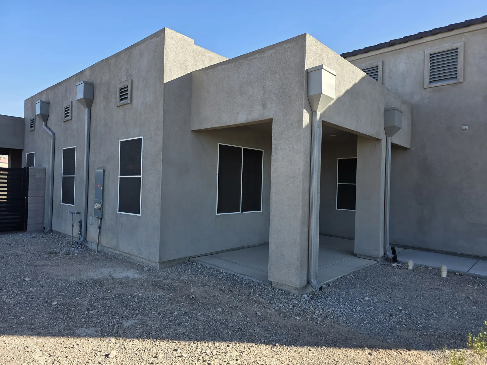 White seamless aluminum box-scupper downspouts on a Santa Fe-style home in Lake Havasu City, AZ