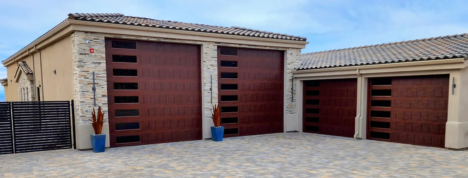 Seamless gutters and downspout along a tile-roof home with mahogany garage doors in Lake Havasu City, AZ