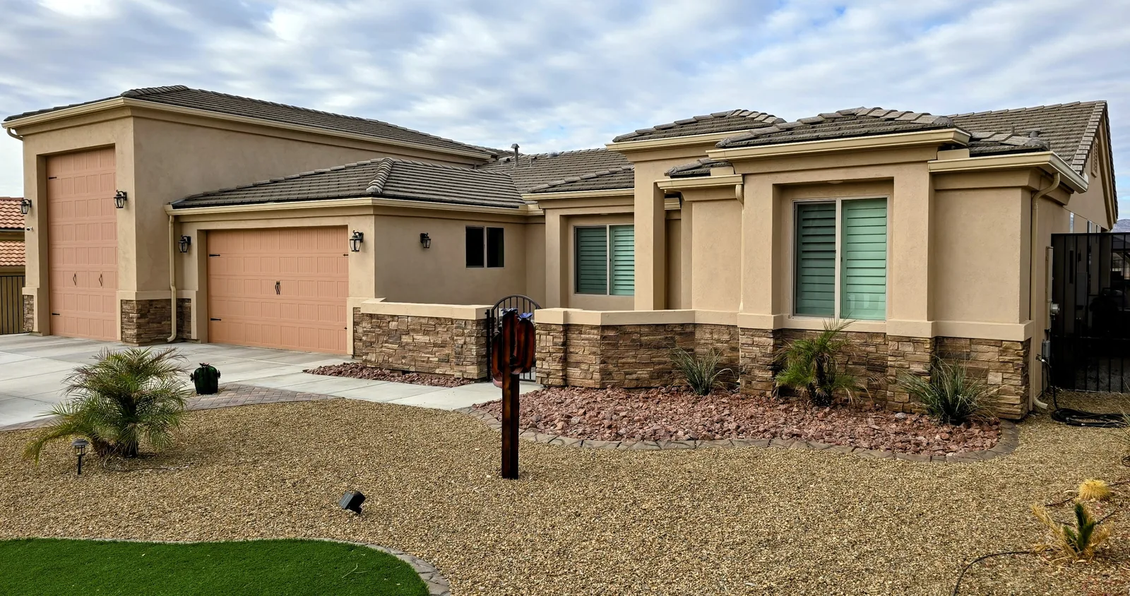 Seamless aluminum gutters on a peach-garage stone-accent home in Bullhead City, AZ