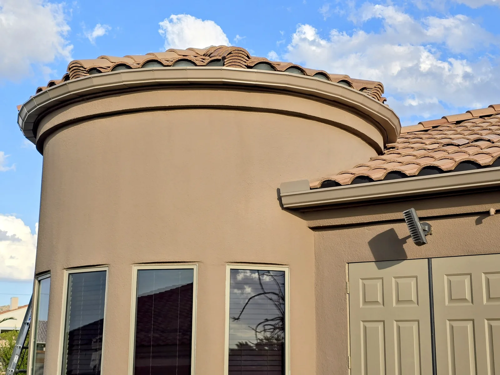 Radius seamless aluminum gutter on a curved turret of a Spanish-style home in Kingman, AZ