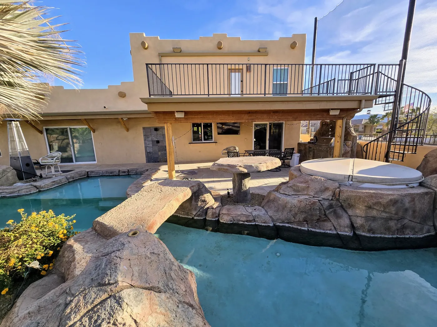 Seamless aluminum gutters on a Santa Fe home with rock pool and spiral stair in Lake Havasu City, AZ