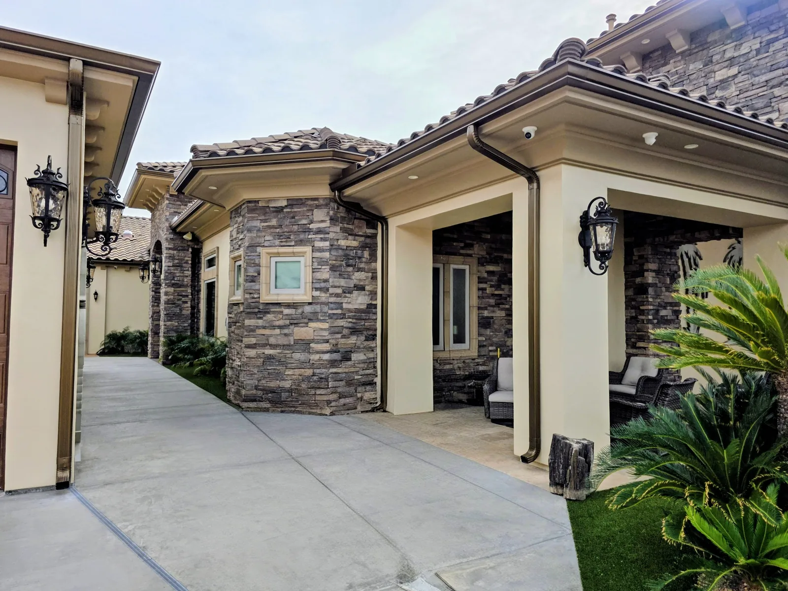 Bronze seamless aluminum gutters and downspouts on a stone-column luxury estate in Bullhead City, AZ