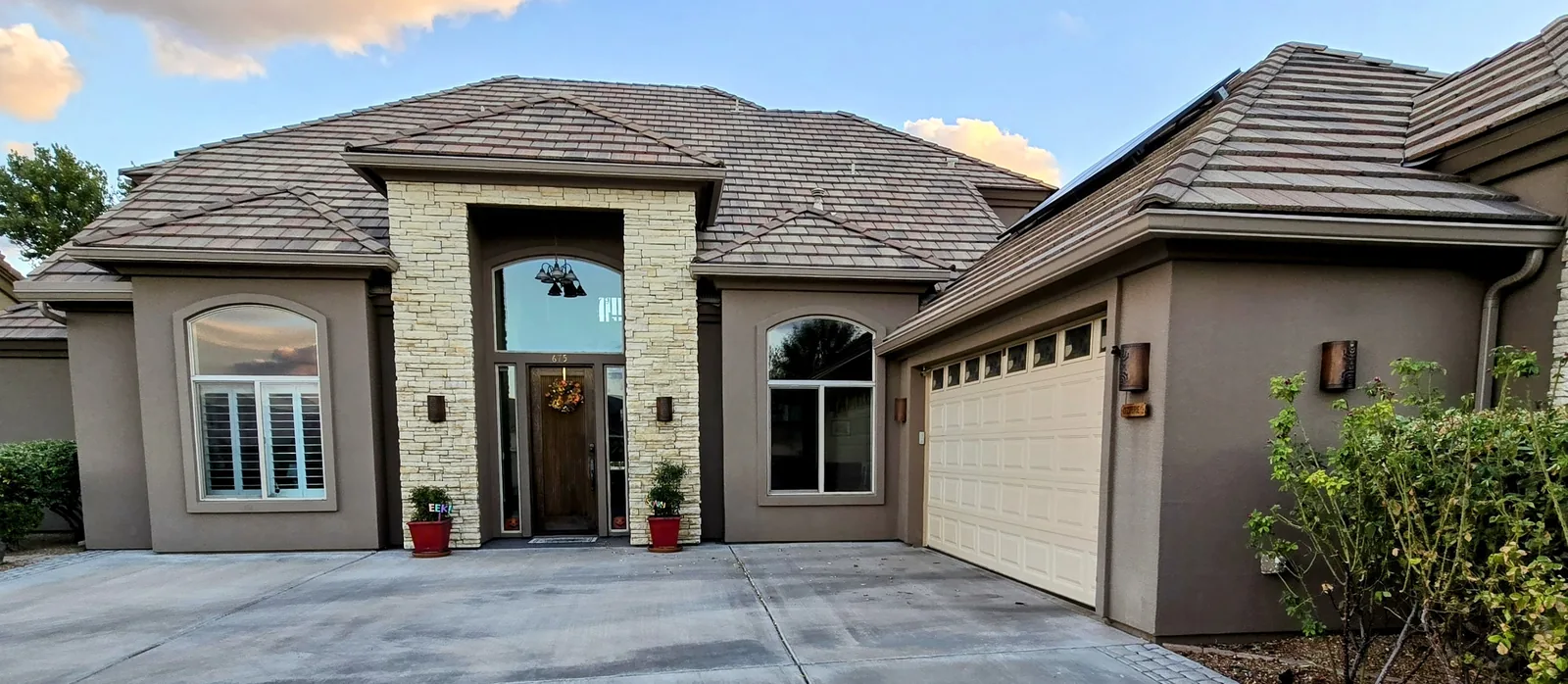 Seamless aluminum gutters on a stone-entry tile-roof estate at dusk in Kingman, AZ