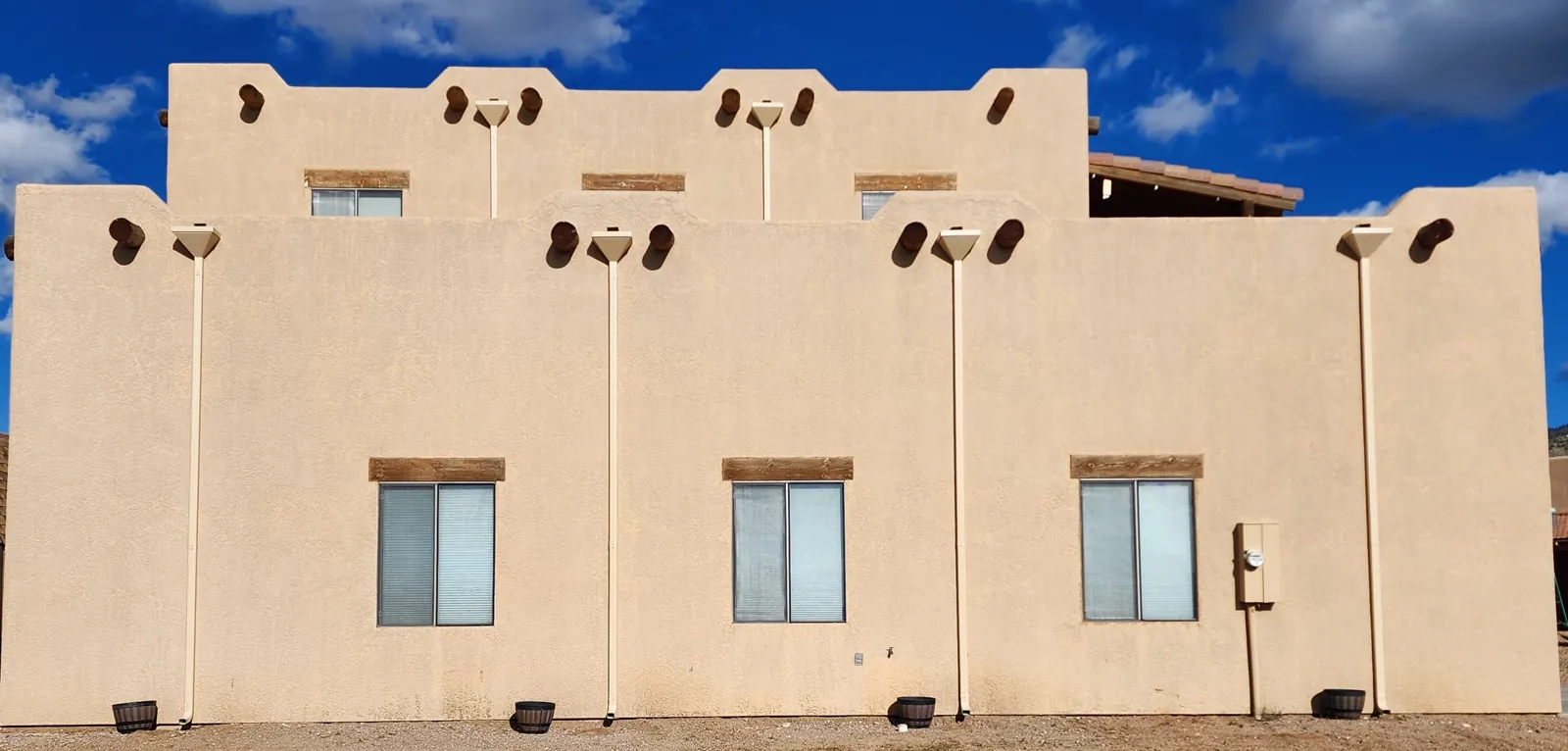 Leaderheads and downspouts on a tan adobe-style home in Kingman, AZ