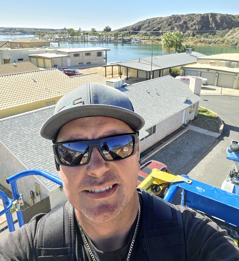Ryan Scheerer on a lift installing seamless rain gutters at a riverfront job site in Mohave County, Arizona