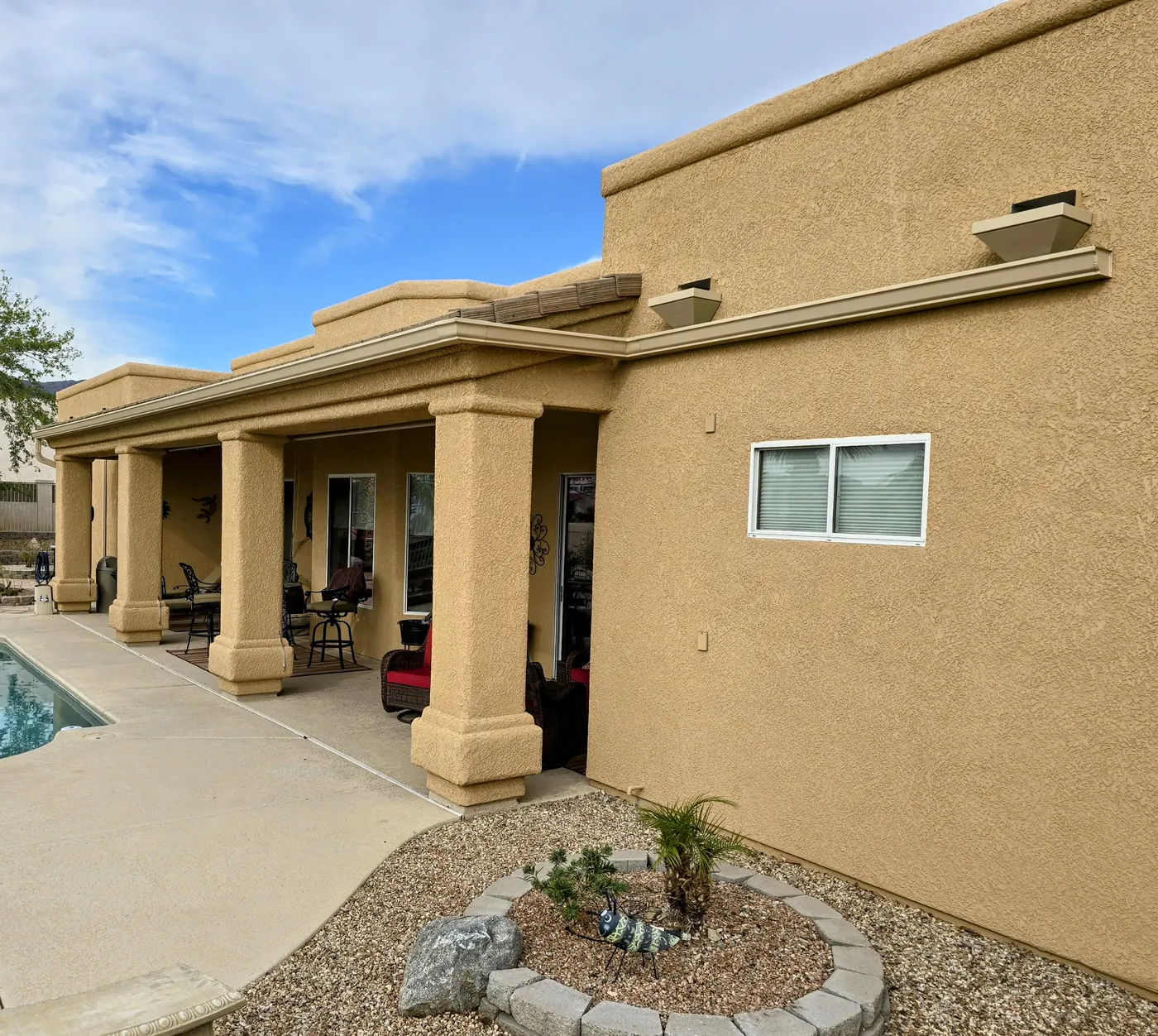 Beige seamless gutters with leaderhead scupper boxes channeling runoff on a Southwest-style stucco home in Lake Havasu City, AZ