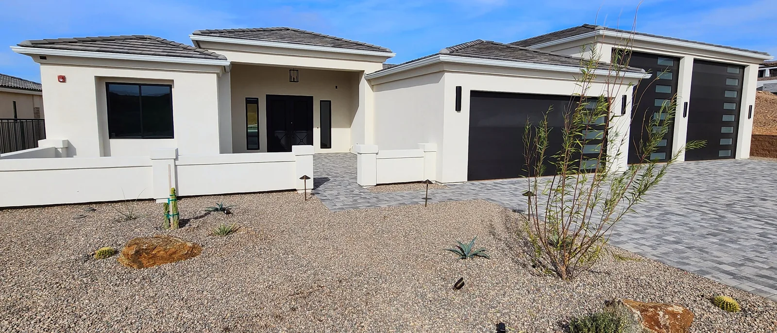 White seamless aluminum gutters along the dark tile roofline of a contemporary home in Lake Havasu City, AZ