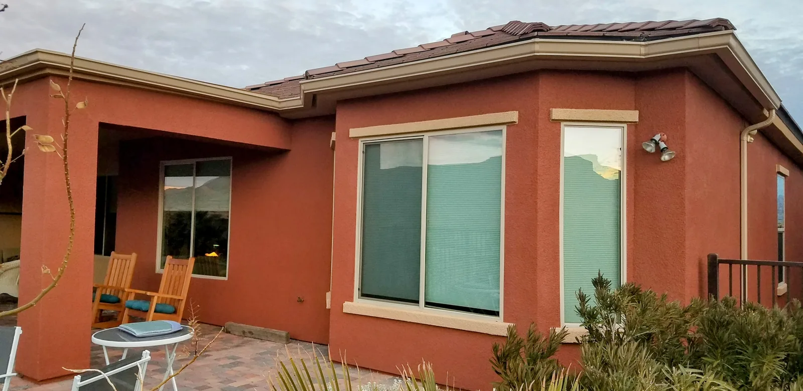 Tan seamless aluminum gutters along the tile-roof eaves of a terracotta stucco home in Mesquite, NV